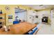 Functional kitchen with white cabinets, a wooden table, and access to an enclosed lanai at 3700 56Th N St, St Petersburg, FL 33710