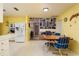 Bright eat-in kitchen area with white appliances, a wooden table, and a view into the living area at 3700 56Th N St, St Petersburg, FL 33710