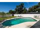 Relaxing backyard pool with lounge chairs and green table set behind a white privacy fence at 3700 56Th N St, St Petersburg, FL 33710