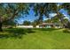 Lush green yard with mature trees, landscaping, and a well-maintained one-story home in the background at 3700 56Th N St, St Petersburg, FL 33710
