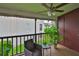 Cozy balcony with chair, table, lush green plants and ceiling fan at 3836 N Lake Dr # 121, Tampa, FL 33614