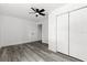 This bedroom features wood-look flooring, a ceiling fan, a closet, and white walls at 4112 E Ellicott St, Tampa, FL 33610
