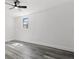 This bedroom features a ceiling fan, a window, and attractive and durable wood-look floors at 4112 E Ellicott St, Tampa, FL 33610