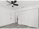 This bedroom features wood-look flooring, a ceiling fan, a closet, and white walls at 4112 E Ellicott St, Tampa, FL 33610