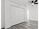 This bedroom features wood-look flooring, a ceiling fan, a closet, and white walls at 4112 E Ellicott St, Tampa, FL 33610