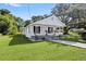Inviting single-story home boasts a classic white exterior, covered porch, and lush green lawn at 4112 E Ellicott St, Tampa, FL 33610