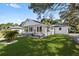 Lovely home featuring a covered front porch and a well-manicured lawn, perfect for outdoor enjoyment at 4112 E Ellicott St, Tampa, FL 33610