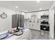 An updated kitchen features stainless steel appliances, white cabinets, and a dining area perfect for Gathering meals at 4112 E Ellicott St, Tampa, FL 33610