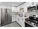 Modern kitchen featuring stainless steel appliances, white cabinets, and countertop space at 4112 E Ellicott St, Tampa, FL 33610