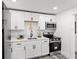 Cozy kitchen features white cabinetry, stainless steel appliances, and a modern black faucet at 4112 E Ellicott St, Tampa, FL 33610