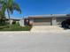 Exterior shot of a charming home with a two-car garage and well-manicured lawn at 587 Boca Ciega Point N Blvd, St Petersburg, FL 33708
