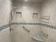 Newly tiled shower with dual shower heads, grab bars, and corner seat at 587 Boca Ciega Point N Blvd, St Petersburg, FL 33708
