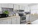 Clean kitchen with white cabinetry, stylish backsplash, and essential appliances at 7608 Pasa Dobles Ct, Tampa, FL 33615