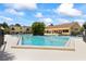 Community pool surrounded by lush landscaping and sunny skies at 7608 Pasa Dobles Ct, Tampa, FL 33615