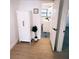 Hallway featuring wood-look floors, a linen closet, and an open doorway to a bathroom with patterned floors at 811 40Th S Ave, St Petersburg, FL 33705