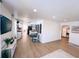 Open-concept living area with wood-look floors leading to a dining area and kitchen with white cabinets at 811 40Th S Ave, St Petersburg, FL 33705