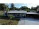 Charming single-story home boasts a metal roof, covered parking, and inviting curb appeal at 8524 Fish Lake Rd, Tampa, FL 33619