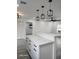 Spacious kitchen features white cabinetry, marble countertops, and a breakfast bar, connecting to the open floorplan at 8524 Fish Lake Rd, Tampa, FL 33619