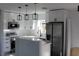 Modern kitchen with stainless steel appliances, white cabinets, and stylish pendant lighting at 8524 Fish Lake Rd, Tampa, FL 33619
