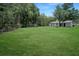Large backyard with a manicured lawn and many shade trees at 8610 Fish Lake Rd, Tampa, FL 33619