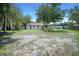 Spacious backyard featuring a charming house with ample green space and mature trees at 8610 Fish Lake Rd, Tampa, FL 33619