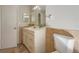 Bathroom featuring a vanity sink, toilet, mirror, and neutral tile walls at 8610 Fish Lake Rd, Tampa, FL 33619