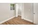 Cozy bedroom featuring wood floors, a window, and a closet with bifold doors at 8610 Fish Lake Rd, Tampa, FL 33619
