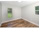 A clean bedroom with neutral walls, floors and two windows at 8610 Fish Lake Rd, Tampa, FL 33619