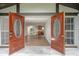 Open front doors offer an inviting glimpse into a home with wood floors and bright spaces at 8610 Fish Lake Rd, Tampa, FL 33619