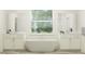 Bright bathroom features a freestanding tub, dual vanities, and a large window with natural light at 9360 Gladsome Dr, Land O Lakes, FL 34637