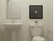 Simple bathroom features a pedestal sink, toilet, and neutral tones, creating a clean and functional space at 9360 Gladsome Dr, Land O Lakes, FL 34637