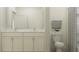 Bathroom with white cabinets, marble countertop, dual sinks, tiled shower with modern fixtures at 9360 Gladsome Dr, Land O Lakes, FL 34637