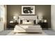 Inviting bedroom featuring a neutral color palette, a plush bed, modern lamps, and stylish decor at 9360 Gladsome Dr, Land O Lakes, FL 34637