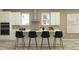 Modern kitchen showcasing a sleek island with seating, stainless steel appliances, and minimalist design at 9360 Gladsome Dr, Land O Lakes, FL 34637