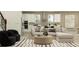 Bright, open-concept living area featuring a sectional sofa flowing seamlessly into the kitchen and dining area at 9360 Gladsome Dr, Land O Lakes, FL 34637