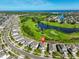 Aerial view of the homes in a community, a pond, a golf course, and a view of the ocean at 955 Signet Dr, Apollo Beach, FL 33572