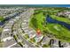 Aerial view of the neighborhood showcasing homes with a golf course, pond, and canal in the distance at 955 Signet Dr, Apollo Beach, FL 33572