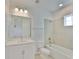 Bright bathroom featuring a tub with tiled shower, a vanity with white cabinets, and a framed mirror at 955 Signet Dr, Apollo Beach, FL 33572