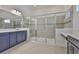 Bright bathroom featuring blue vanity, quartz countertops, and a glass-enclosed shower at 955 Signet Dr, Apollo Beach, FL 33572