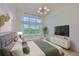 Bright bedroom with a large window, plush bed, stylish lighting, and neutral decor for a relaxing space at 955 Signet Dr, Apollo Beach, FL 33572