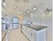 This kitchen features an island with a sink, stainless steel appliances, white cabinets, and modern pendant lighting at 955 Signet Dr, Apollo Beach, FL 33572