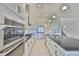 This open-concept kitchen features stainless steel appliances, white cabinets, an island, and modern pendant lighting at 955 Signet Dr, Apollo Beach, FL 33572