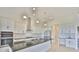 Modern kitchen with stainless steel appliances, white cabinets, an island with a sink, and pendant lighting at 955 Signet Dr, Apollo Beach, FL 33572