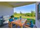 Covered patio with a dining table and chairs, a grill, and scenic views of the green lawn at 955 Signet Dr, Apollo Beach, FL 33572