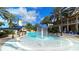 Fun community pool with a splash fountain, slide, and lighthouse, surrounded by lush landscaping at 955 Signet Dr, Apollo Beach, FL 33572