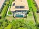 Aerial view showcasing a private screened-in pool, solar panels and lush landscaped backyard for outdoor enjoyment at 1014 Stella Vara Dr, Lutz, FL 33548