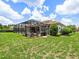 The backyard shows a screened-in pool and outdoor living area, surrounded by lush landscaping at 1014 Stella Vara Dr, Lutz, FL 33548