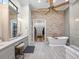 Bathroom featuring stone accent wall, soaking tub, and doorway to walk in closet at 1014 Stella Vara Dr, Lutz, FL 33548
