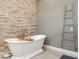 Elegant bathroom features stone accent wall and soaking tub, creating a spa-like retreat at 1014 Stella Vara Dr, Lutz, FL 33548