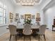 Formal dining room with seating for eight under an elegant chandelier with views of the landscaped yard at 1014 Stella Vara Dr, Lutz, FL 33548